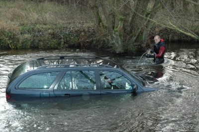 DLRG Rettungstaucher Christian Wehde befestigt Seile am gestrandeten Mercedes. Foto: Schwartau