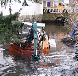 Schlamm und Schrott in der Este verstopfen den Zulauf zum Fleth: Damit der historische Hafen im Sommer nicht zum Himmel stinkt, hat die Stadtentwässerung den Bagger in Marsch gesetzt. Foto: Vasel