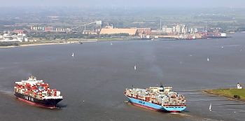 Zwischen Ökologie und Ökonomie: der Lebensraum Unterelbe. Hier treffen sich vor dem Industriegebiet Bützfleth zwei schwer beladene Container-Riesen. Foto:  Schmidt