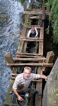 Marode Fischtreppe: Mit Schnellbeton stopfen die Angler Manfred Kraus und Eckart Bösche die Löcher. Foto: Vasel